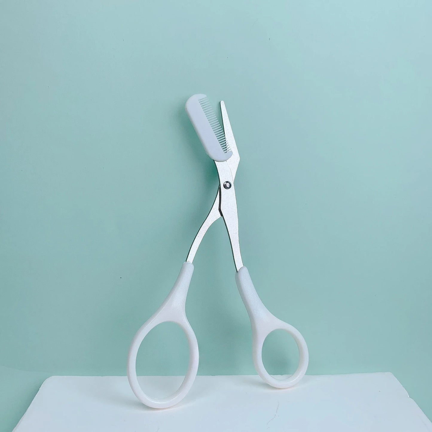 Pink eyebrow trimming scissors with built-in comb - stainless steel, precise grooming tool, creating perfect eyebrows